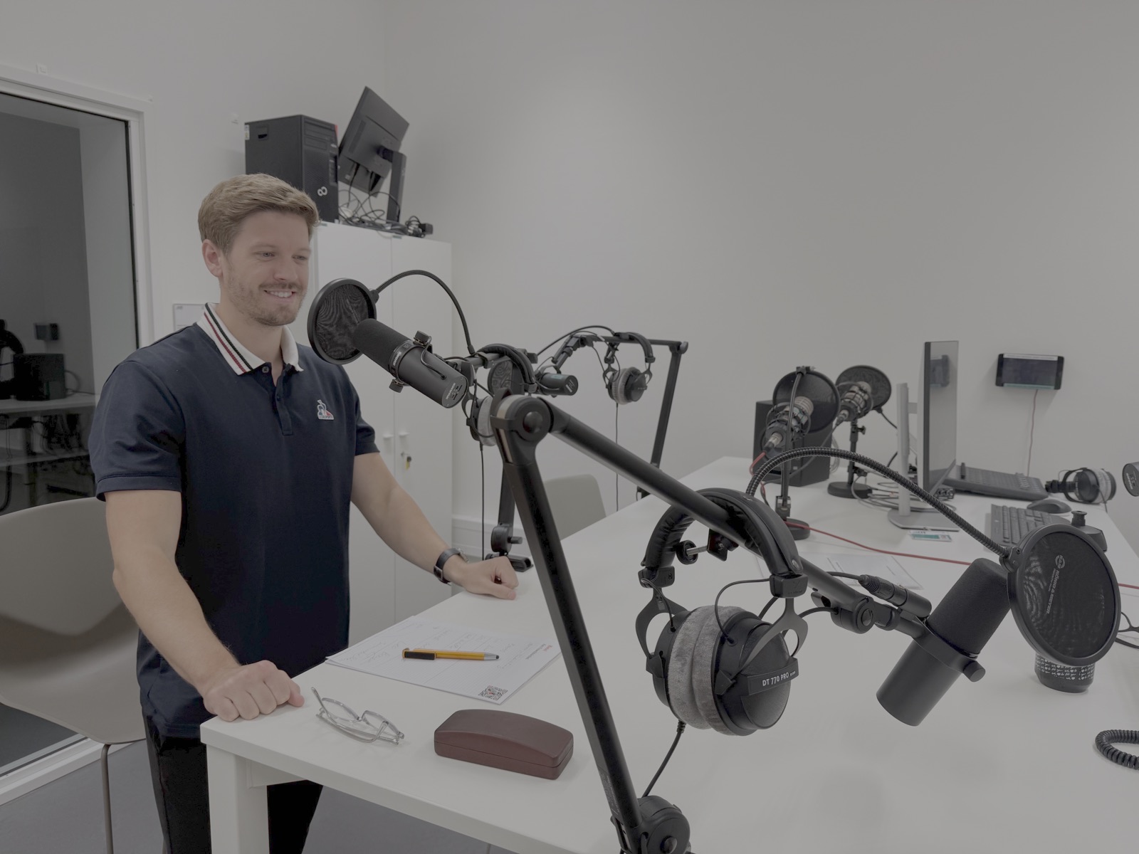 Aufnahme im Podcast-Studio mit Mikrofonen und Kopfhörern auf dem Tisch